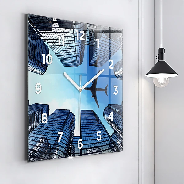 Wanduhr quadratisch mit motiv Flugzeug über Gebäuden
