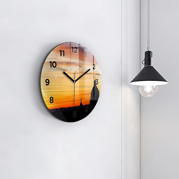 Wanduhr rund Gebäude und Sonnenuntergang